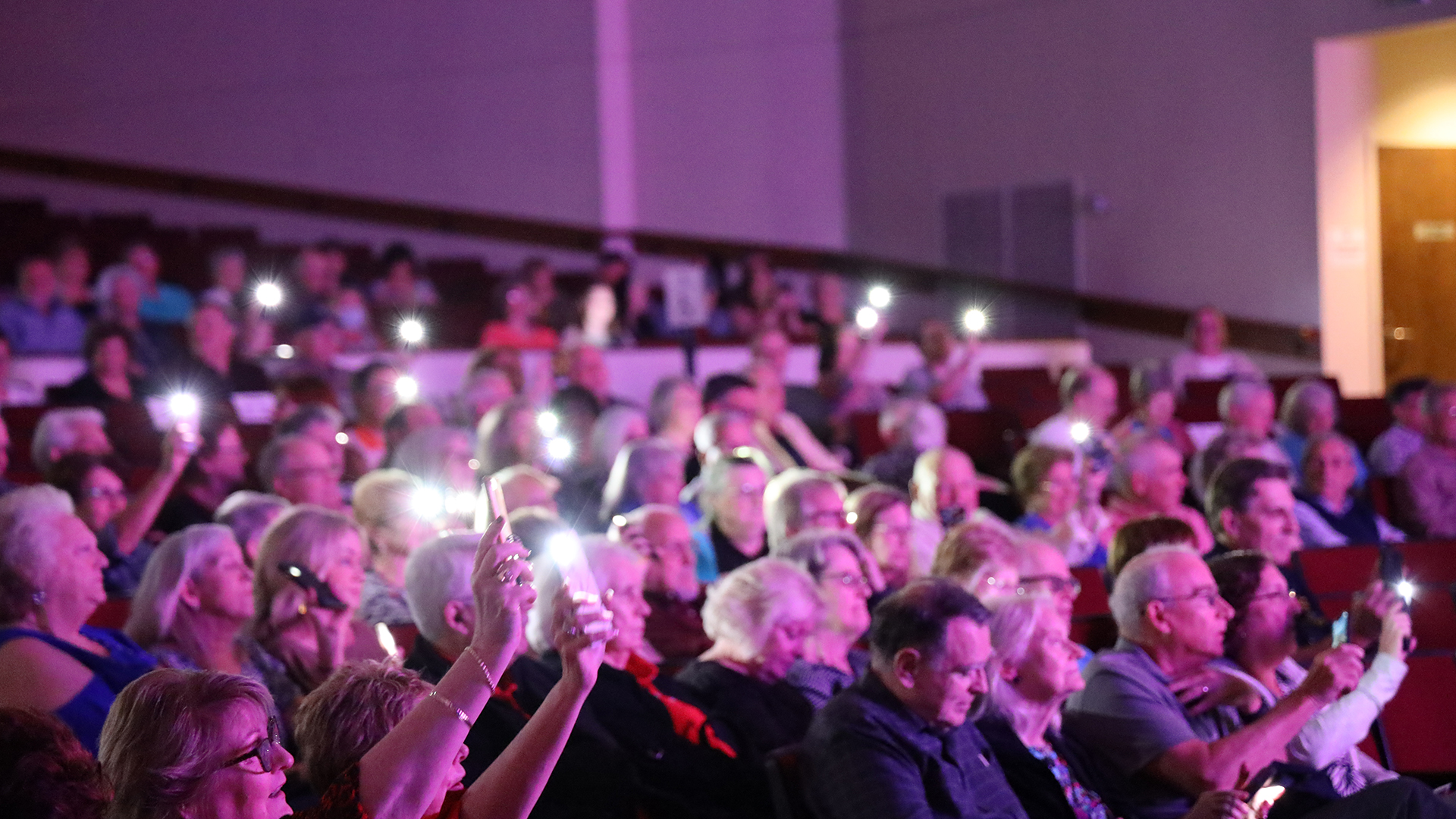 Audience holding up phones with lights on.